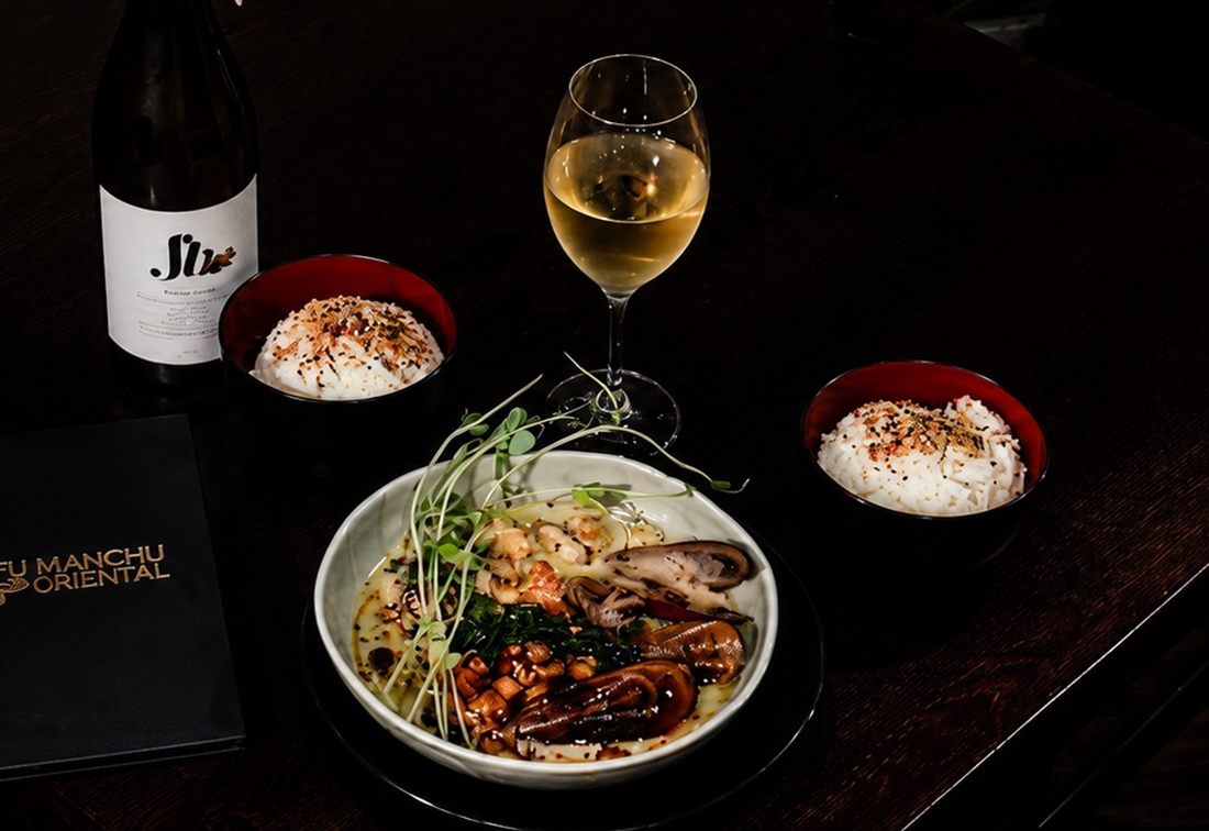 A shared bowl with steamed rice and a glass of white wine